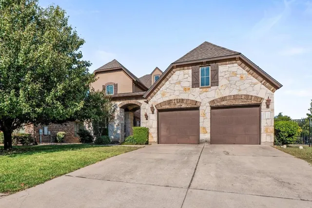 a front view of a house with a garden and trees