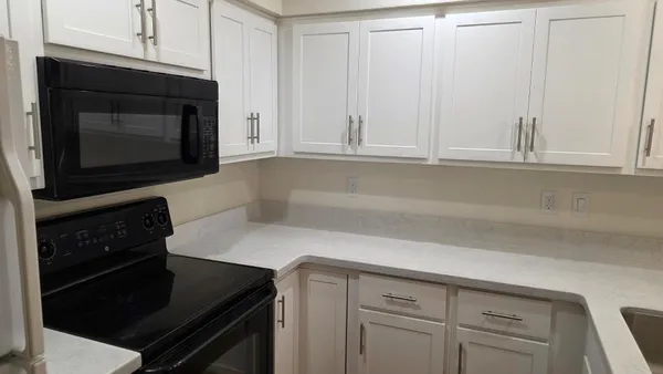 a kitchen with white cabinets and a stove