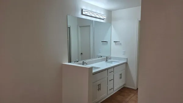 a spacious bathroom with a granite countertop sink and a mirror