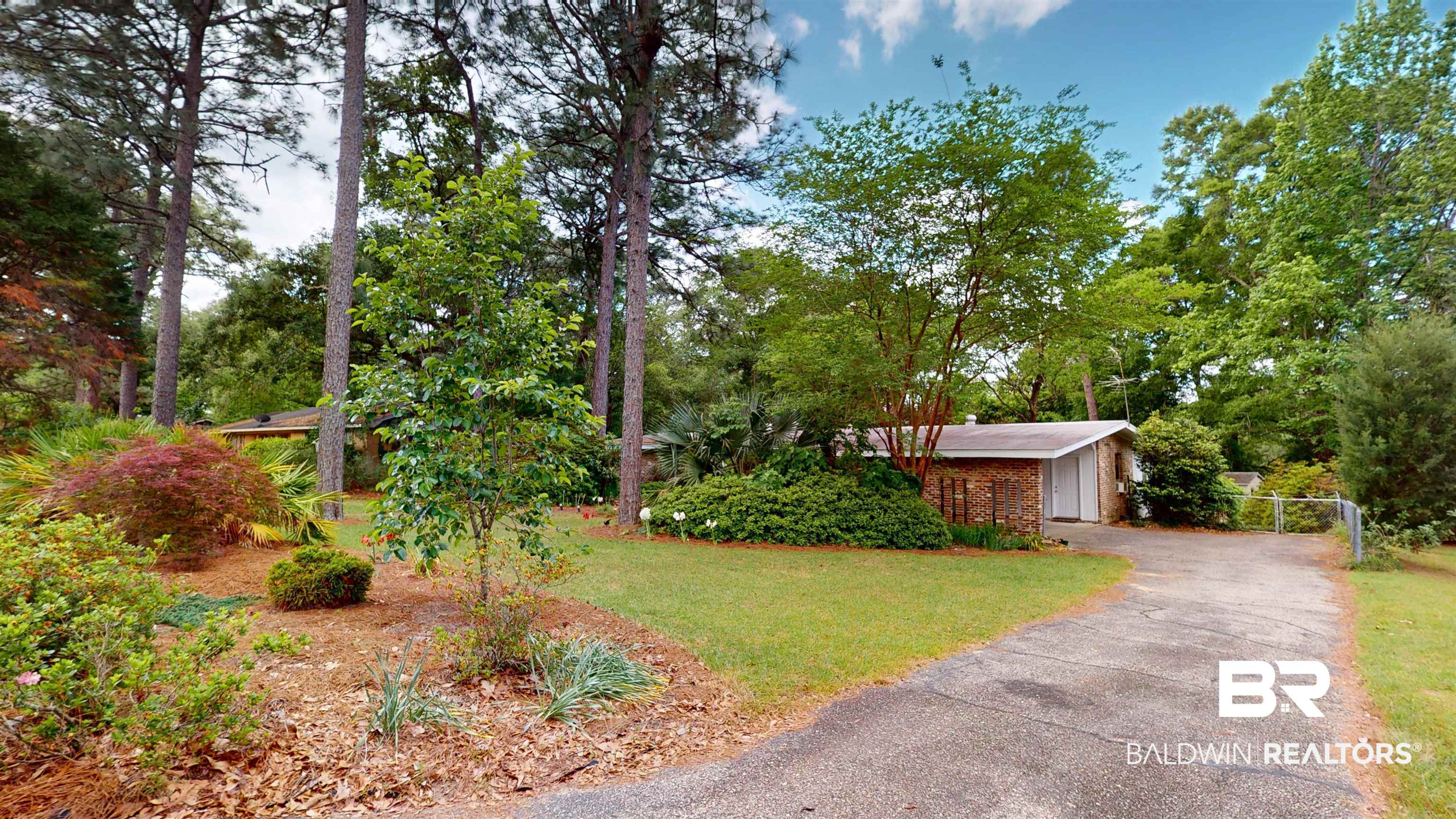 1075 Zurich Street Mobile, AL 36608 - Photo 4 of 35 View of front of house with a front yard, view of scattered trees, and a detached garage