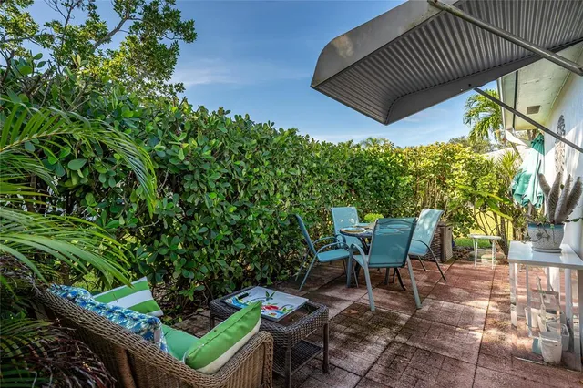 a patio with table and chairs and potted plants