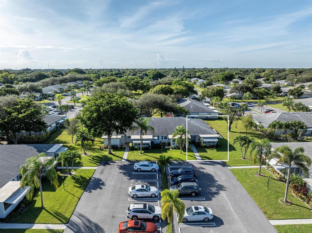 1130 Cir Terrace West, Unit D Delray Beach, FL 33445 - Photo 37 of 39 an aerial view of a swimming pool with lawn chairs and large trees