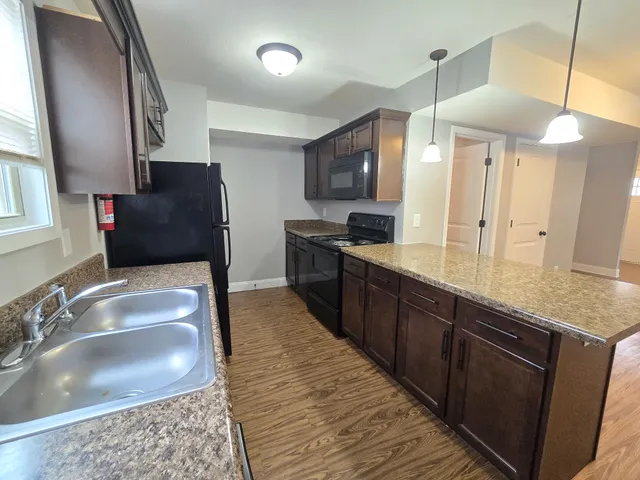 a large kitchen with stainless steel appliances kitchen island granite countertop a sink and a granite counter tops