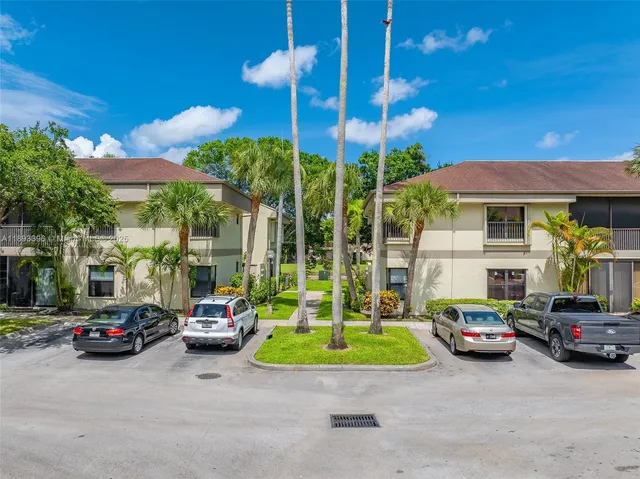 a view of a cars park in front of a building