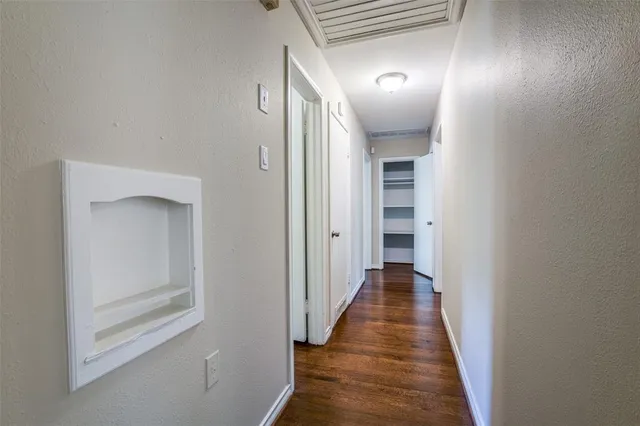 a view of a hallway with wooden floor and closet
