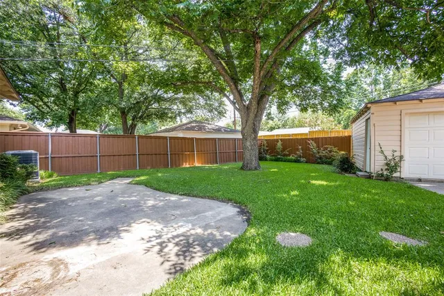 a view of a yard with a house and large trees