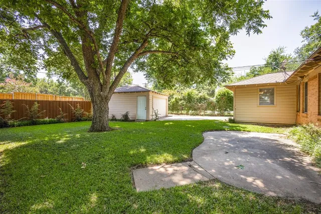 a view of a house with backyard and a tree