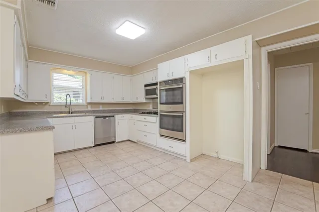 a kitchen with a cabinets and steel stainless steel appliances