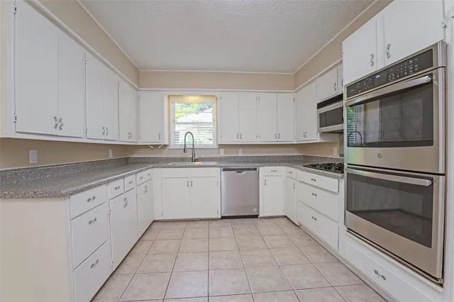 a kitchen with cabinets appliances and a sink