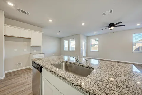 a kitchen with granite countertop a sink and wooden floor