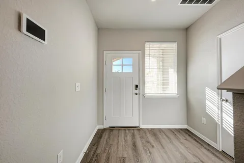 a view of empty room with wooden floor and window