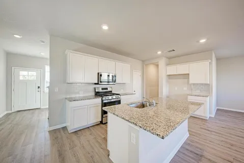 a large kitchen with a lot of counter space and a wooden floor