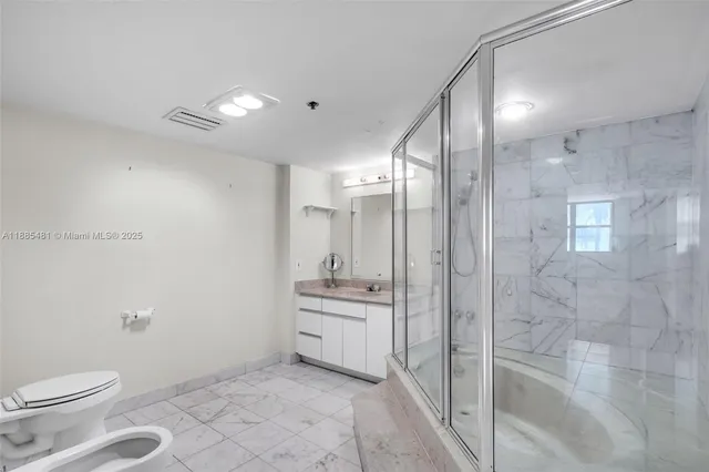 a bathroom with a granite countertop sink a toilet and shower