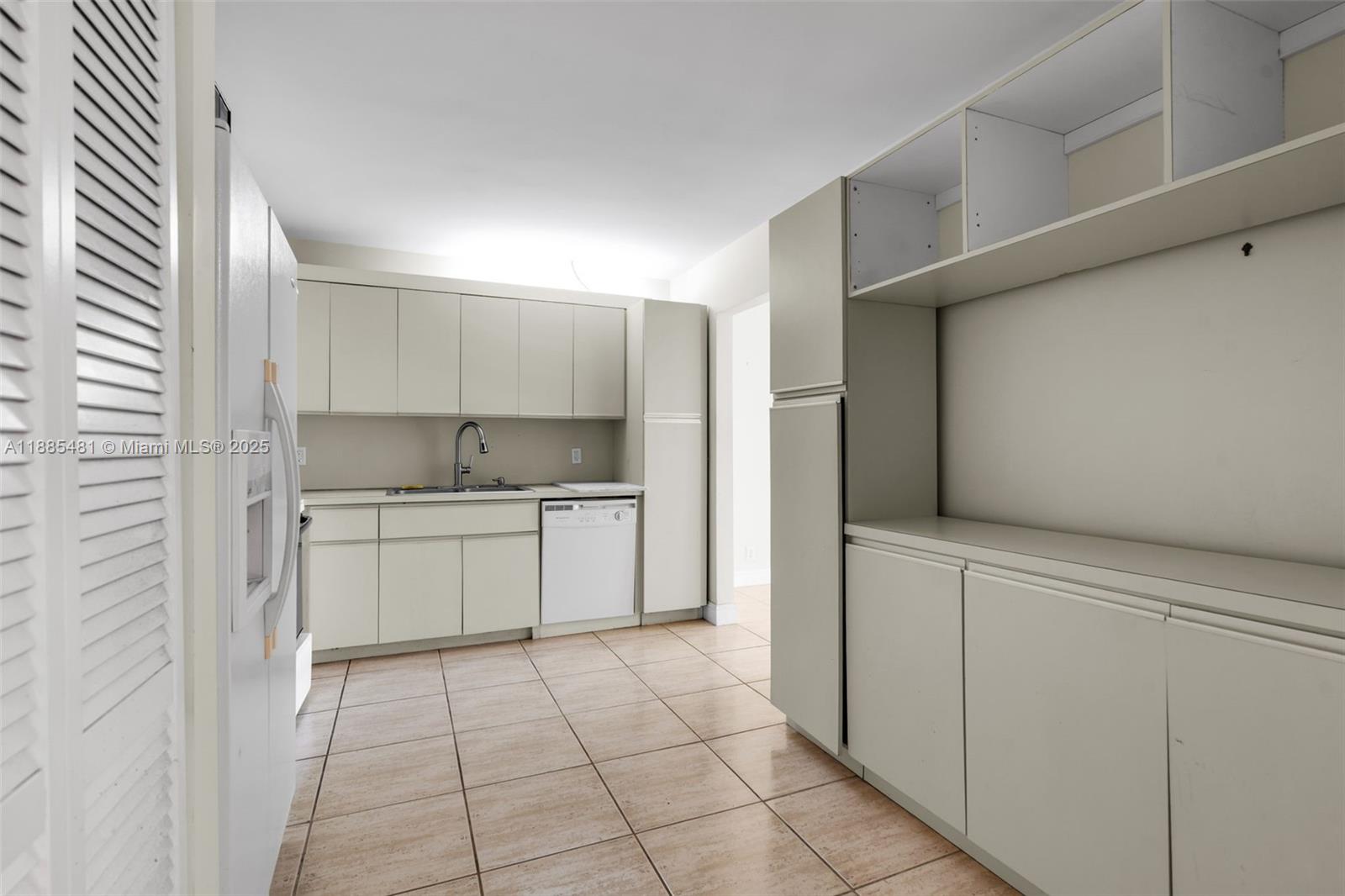 8877 Collins Avenue, Unit 303 Surfside, FL 33154 - Photo 8 of 25 a kitchen with a stove top oven a sink and cabinets