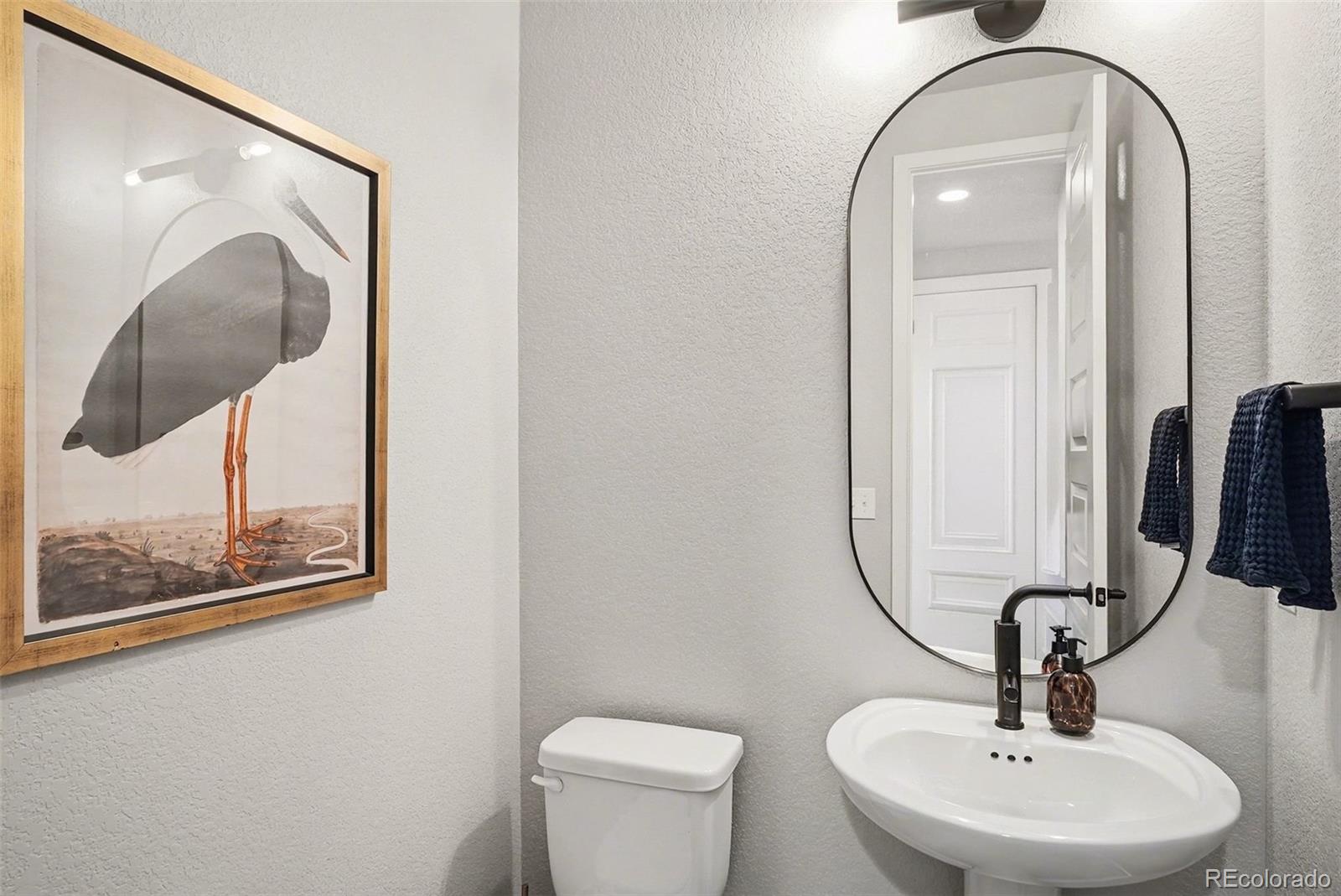 6793 Canosa Street Denver, CO 80221 - Photo 12 of 34 a bathroom with a toilet sink and mirror