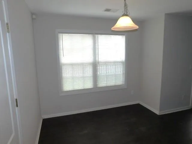 an empty room with wooden floor and a window