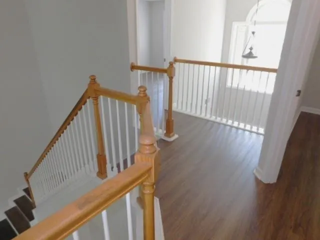 a view of staircase with railing and white walls