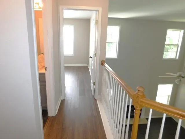 a view of a hallway with wooden floor and stairs