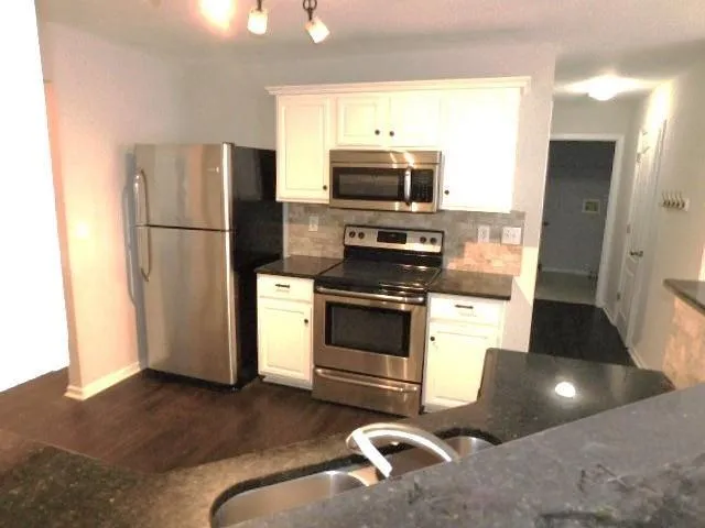 a kitchen with stainless steel appliances a refrigerator stove and microwave