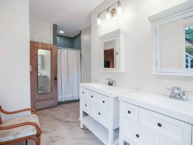 a spacious bathroom with a double vanity sink a mirror and a bathtub