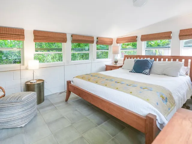 a bedroom with a bed and a large window