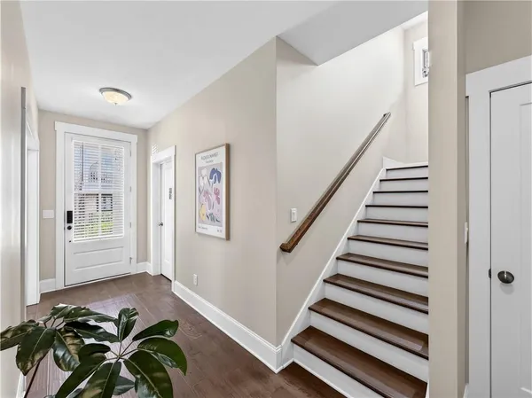 a living room with furniture kitchen view and a wooden floor