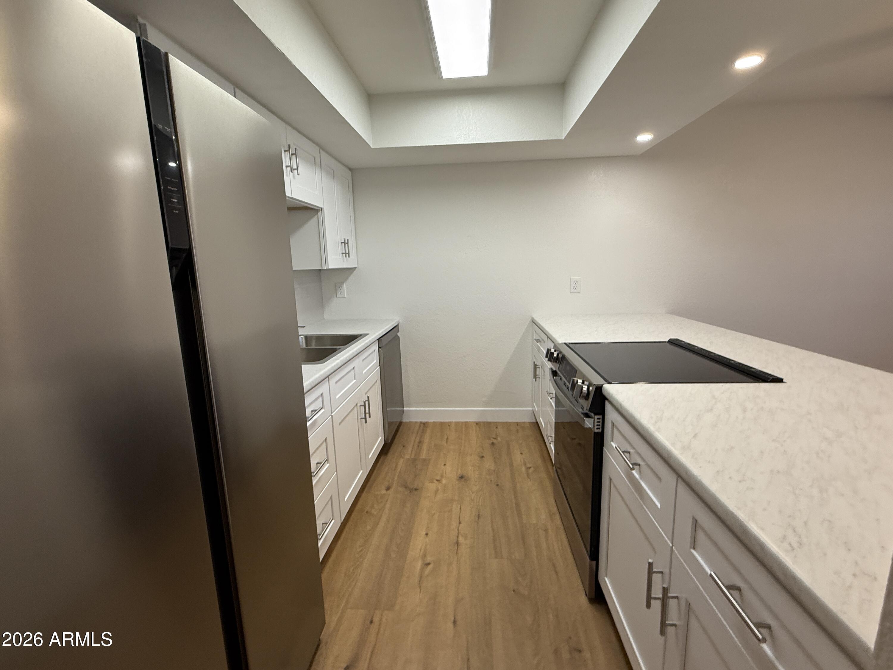 18202 North Cave Creek Road, Unit 148 Phoenix, AZ 85032 - Photo 10 of 19 a kitchen with a sink and wooden floor