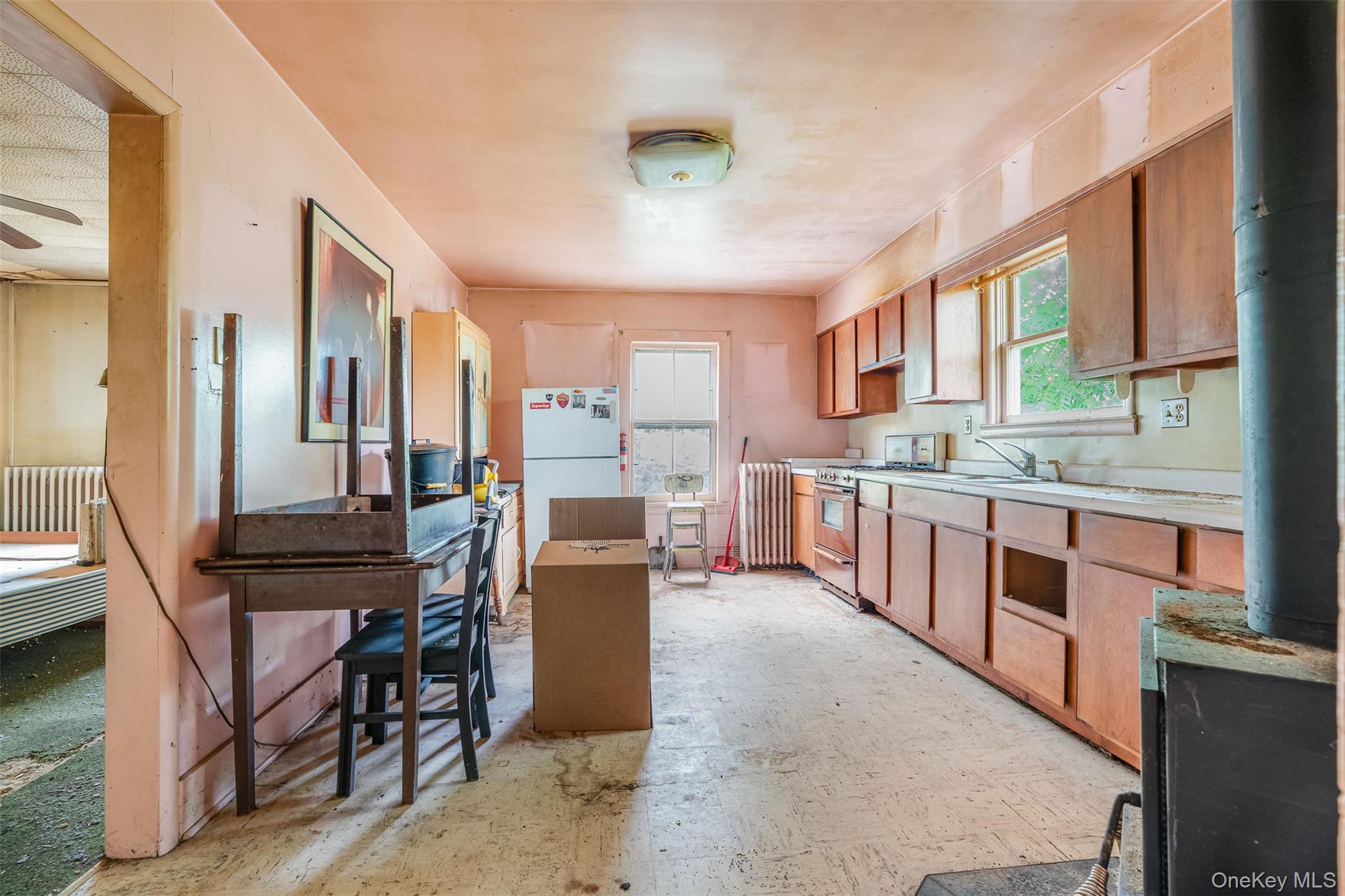 50 Maple Street Catskill, NY 12414 - Photo 12 of 27 a kitchen with stainless steel appliances kitchen island granite countertop a table chairs and a refrigerator
