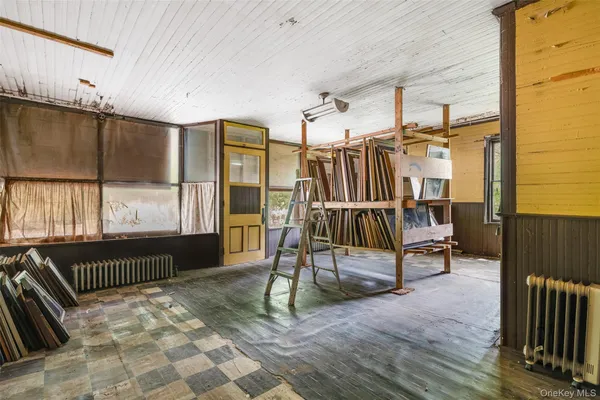 a view of a hallway with wooden floor and door