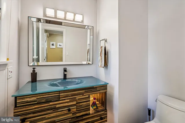 a kitchen with stainless steel appliances granite countertop a refrigerator a sink dishwasher a stove and a large window with wooden floor