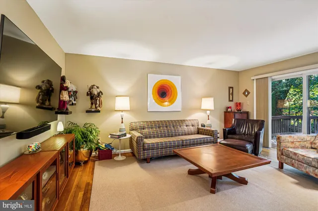 a backyard of a house with plants and large tree