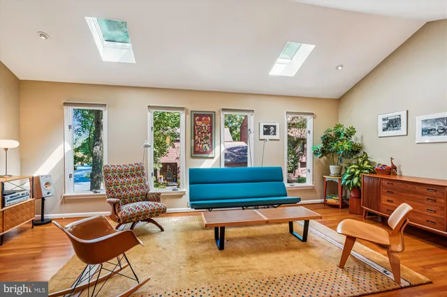 a bedroom with a large bed and large windows