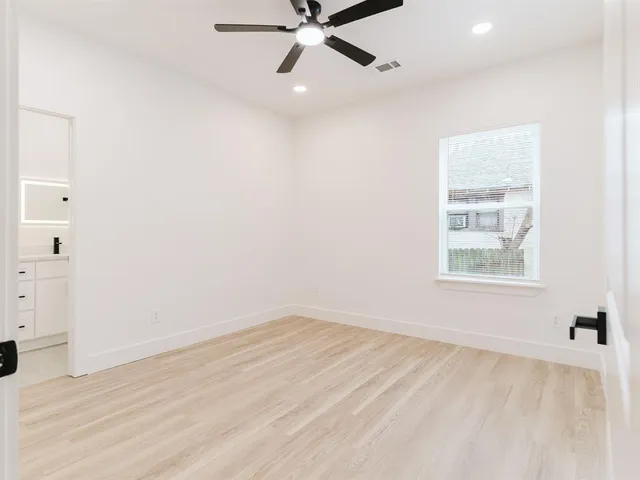 an empty room with a window and a ceiling fan