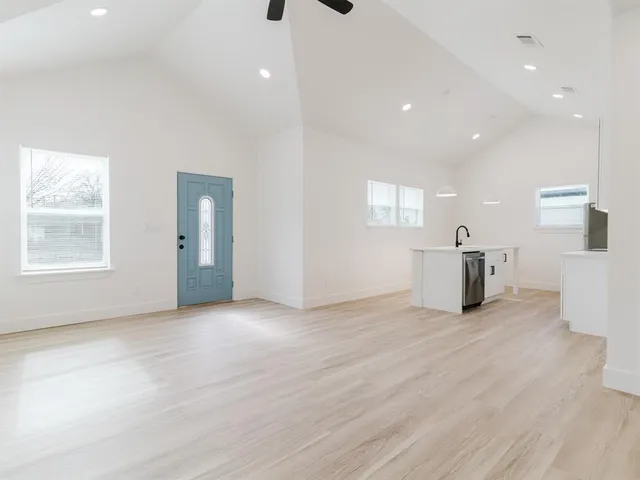 a view of an empty room with window and wooden floor