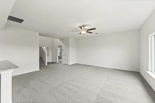 an empty room with a ceiling fan and a window