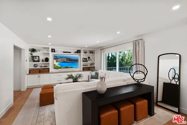 a living room with furniture a floor to ceiling window and wall