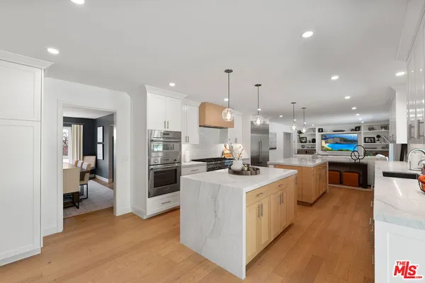a kitchen with stainless steel appliances kitchen island granite countertop a stove and a refrigerator
