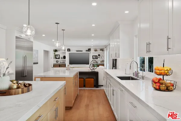 a kitchen with counter top space a sink wooden floor and stainless steel appliances