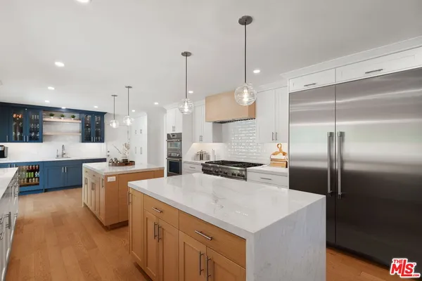 a kitchen with stainless steel appliances granite countertop a sink a stove and a refrigerator