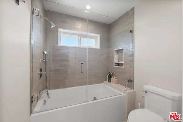 a white bath tub sitting next to a white toilet and a sink