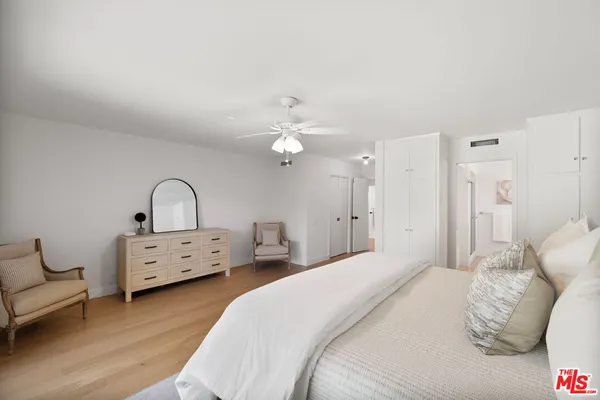 a spacious bedroom with a bed and a chandelier