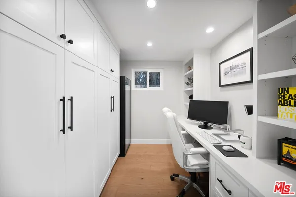 a view of a workspace with furniture and a window