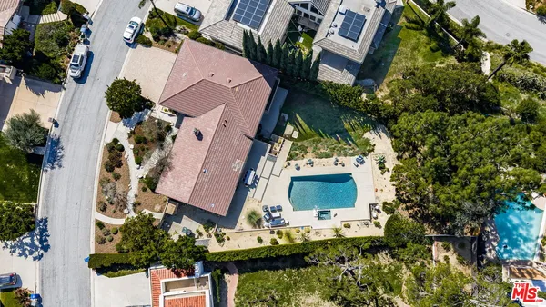 an aerial view of a house with a yard and a large tree