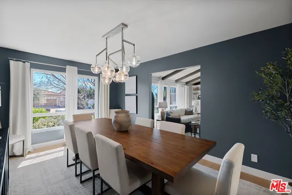 a dining room with furniture a chandelier and wooden floor