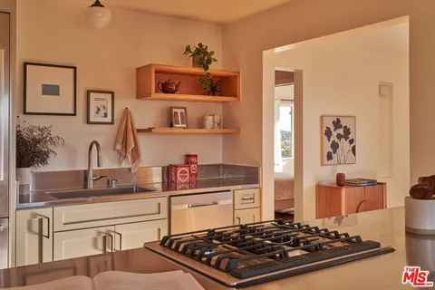 a kitchen with kitchen island a stove and a sink