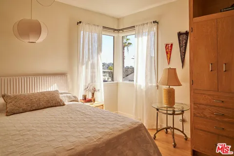 a bedroom with a bed and a dresser with mirror