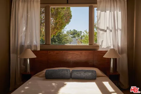 a couch sitting in a bedroom next to a window