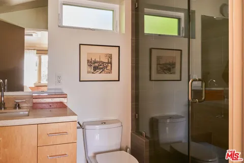 a bathroom with a toilet sink vanity and mirror