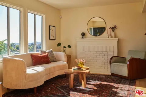 a living room with furniture and a floor to ceiling window