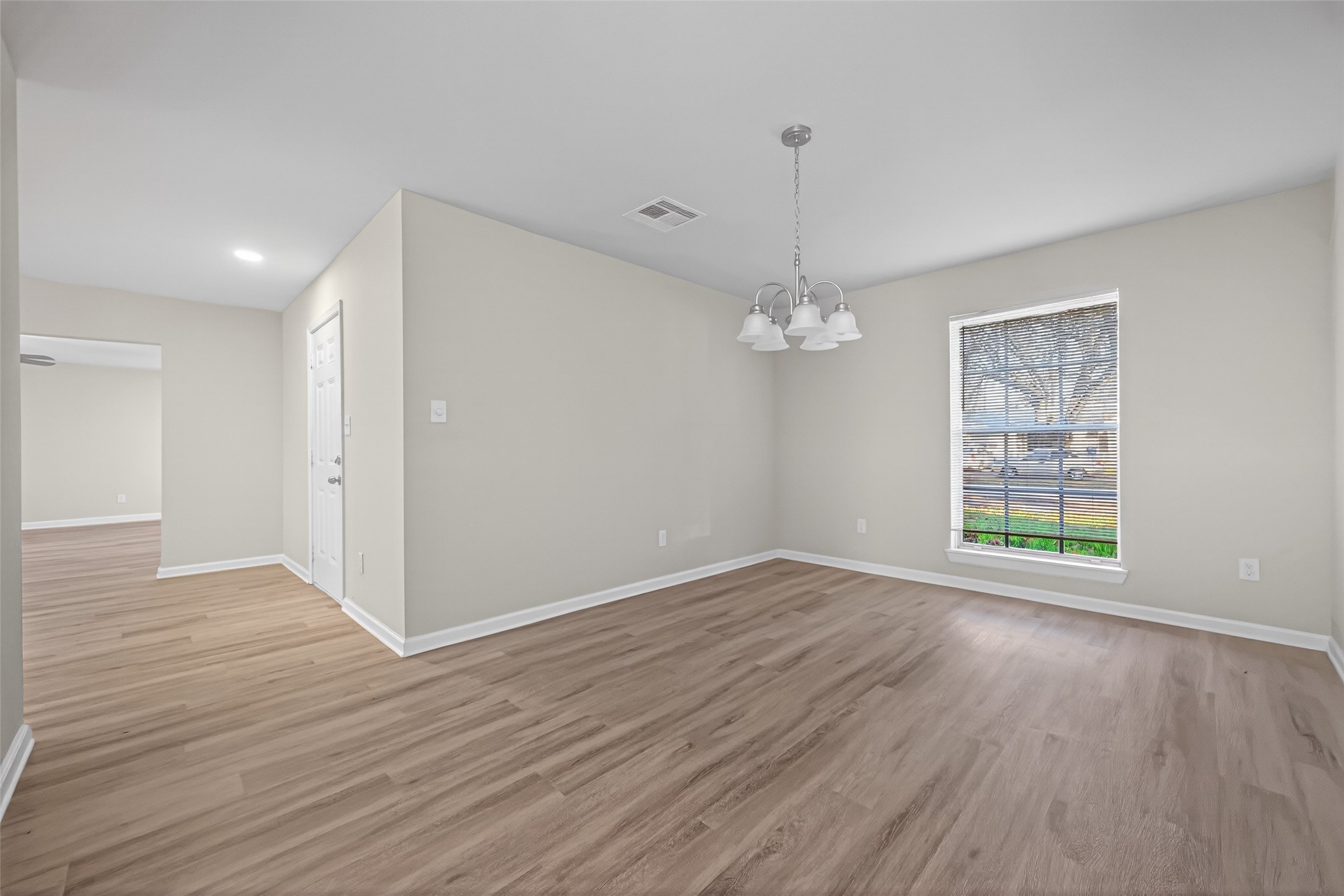 1238 Hopper Road Houston, TX 77037 - Photo 22 of 40 a view of an empty room with wooden floor and a window